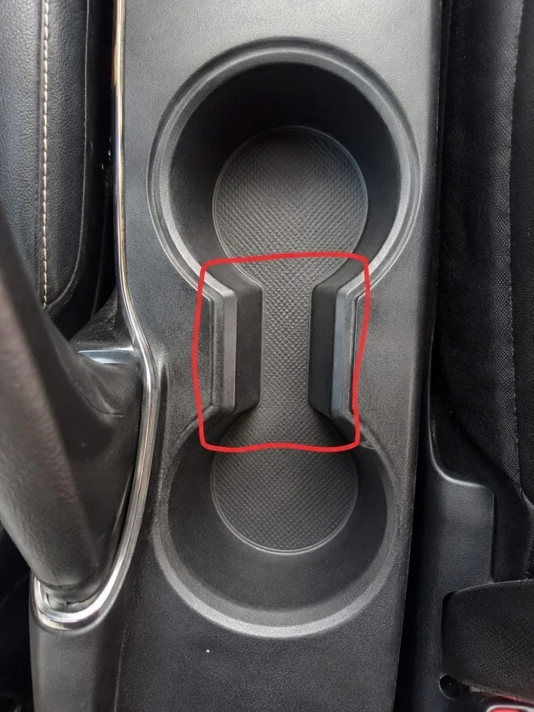 Qual è lo scopo di quello strano spazio tra i portabicchieri dell’auto?…